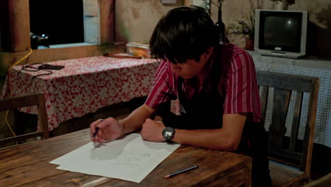 un joven empresario prepara un boceto de un nuevo invento en la mesa de la cena