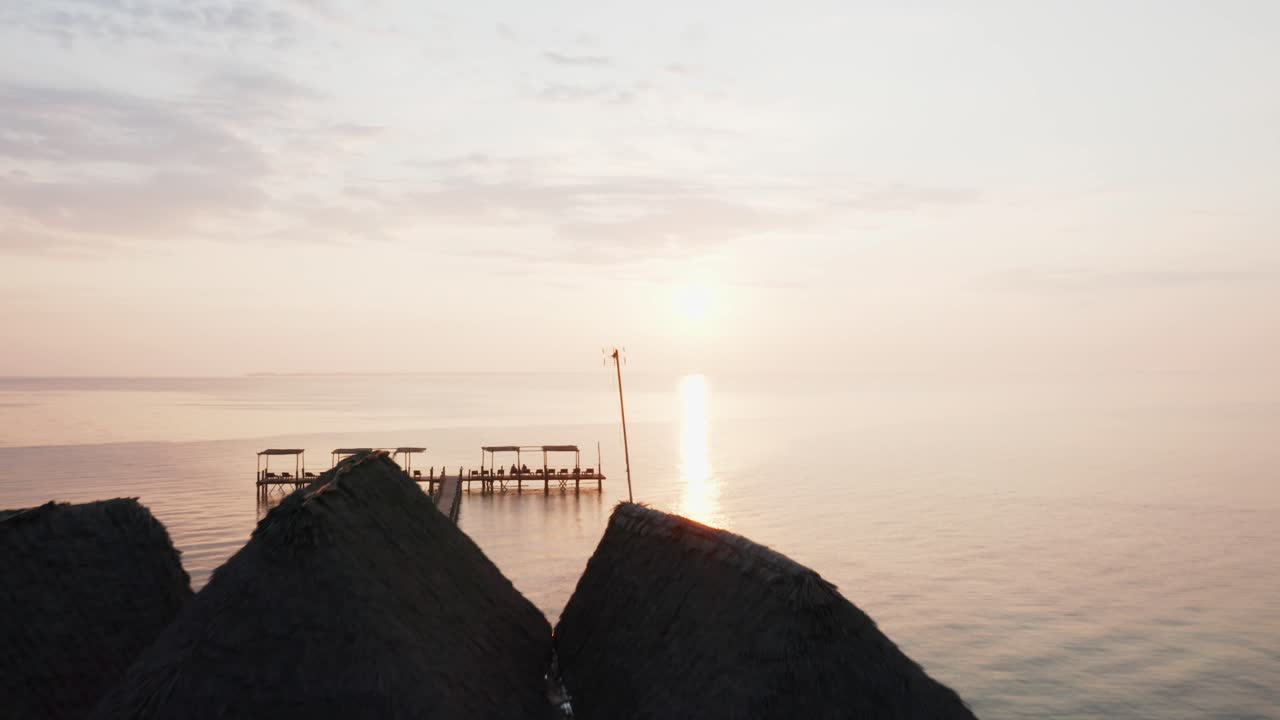Aerial drone view of an amazing sunrise flying forward over a pier. Zanzibar, Tanzania.