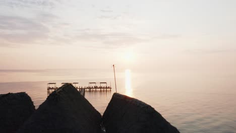 aerial drone view of an amazing sunrise flying forward over a pier. zanzibar, tanzania.