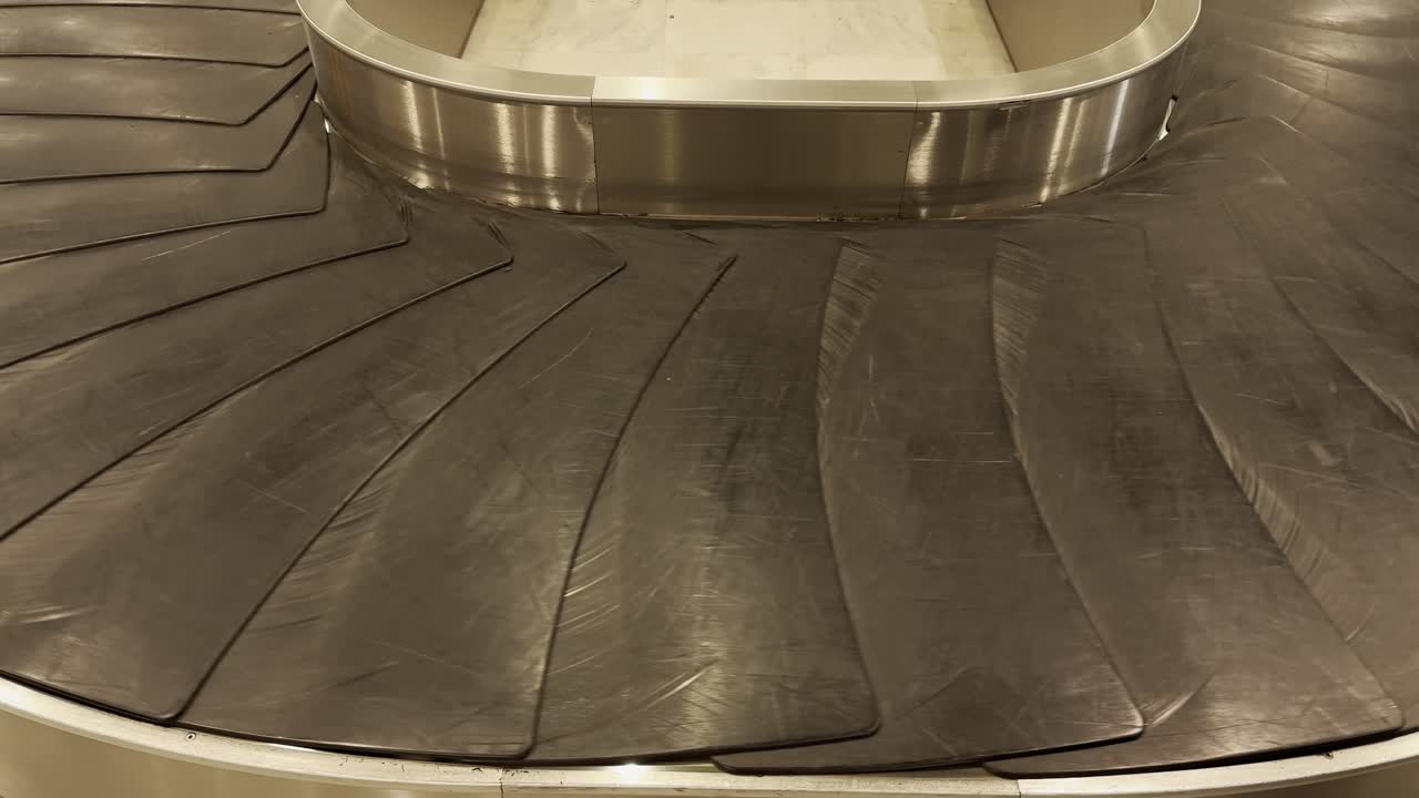 bags and suitcases move along conveyor belt in the baggage reclaim hall at the airport