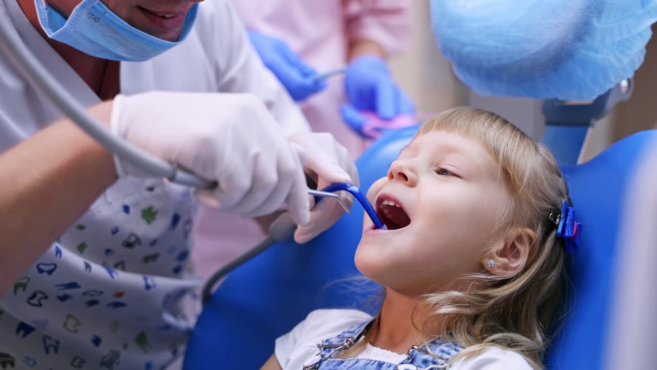 Cute girl in dental clinic. Professional dentist working with little girl in clinic