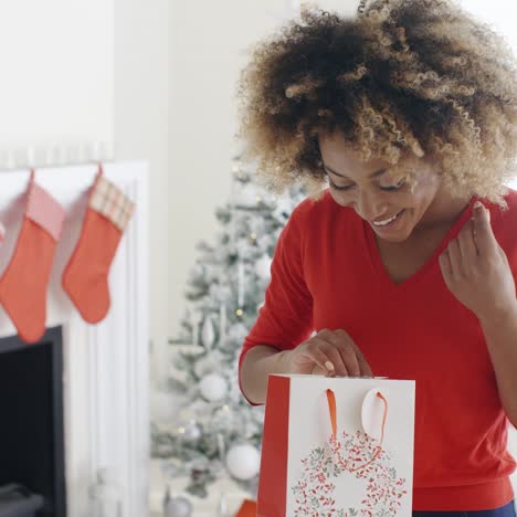 astonished young woman holding a christmas gift