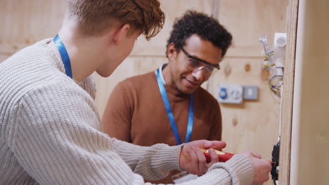 tutor con un aprendiz de electricista en el taller estudiando para el aprendizaje en la universidad