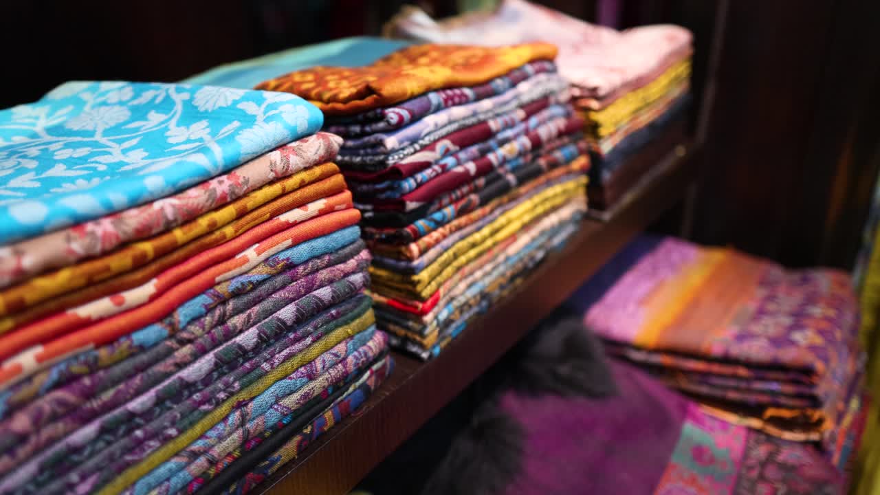 telas de colores cuidadosamente apiladas en estantes de exhibición