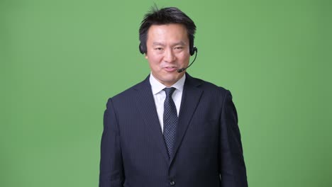녹색 배경에 성숙한 일본 사업가