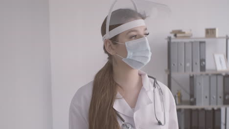 Redhead-Doctor-Woman-In-White-Coat-Wearing-Medical-Mask-And-Facial-Screen-Protection