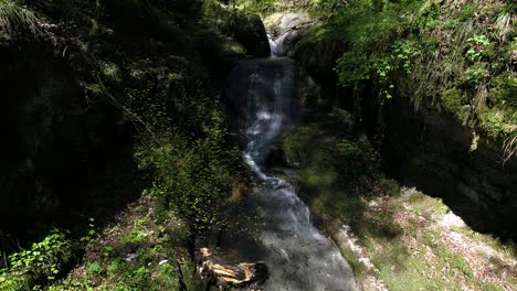 aerial view of little waterfall at a stream inside a canyon switzerland