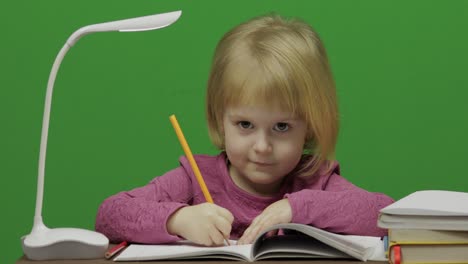 girl drawing at the table. education process in classroom. chroma key