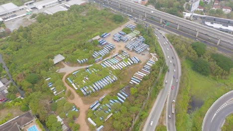 aerial top view of truck, bus cars parking stock lot row in industry factory, dealer inventory import and export business commercial, automobile and automotive industry distribution logistic transport