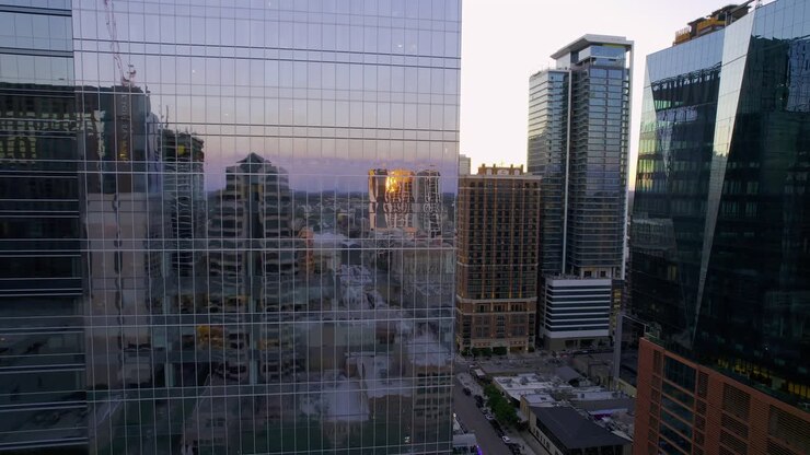 Vista aérea de ruas da cidade e edifícios refletidos em janelas de vidro urbanas.