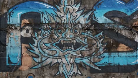 Graffiti-Street-Art-on-Concrete-Wall-Decorated-with-Blue-Paint-and-Signature-with-Dragon-Logo-in-Thailand