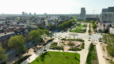 Aerial-flight-over-grass-field-and-Zuid-park-in-Antwerp-Cityscape-during-sunny-day,-Belgium