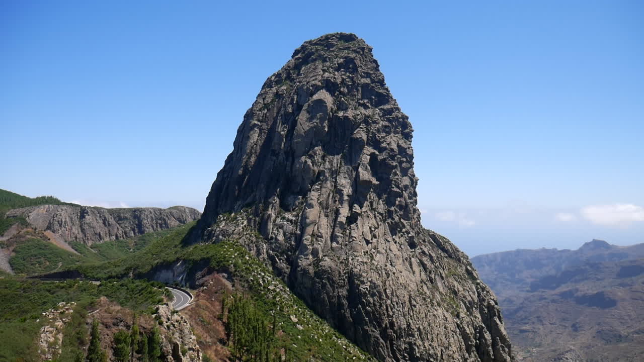 Impressive view of Roque Agando, a volcanic plug on La Gomera island, showcasing its unique geological formation against a clear blue sky