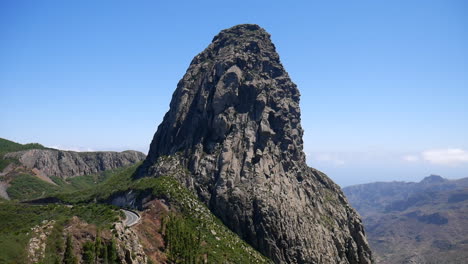 impressive view of roque agando, a volcanic plug on la gomera island, showcasing its unique geological formation against a clear blue sky