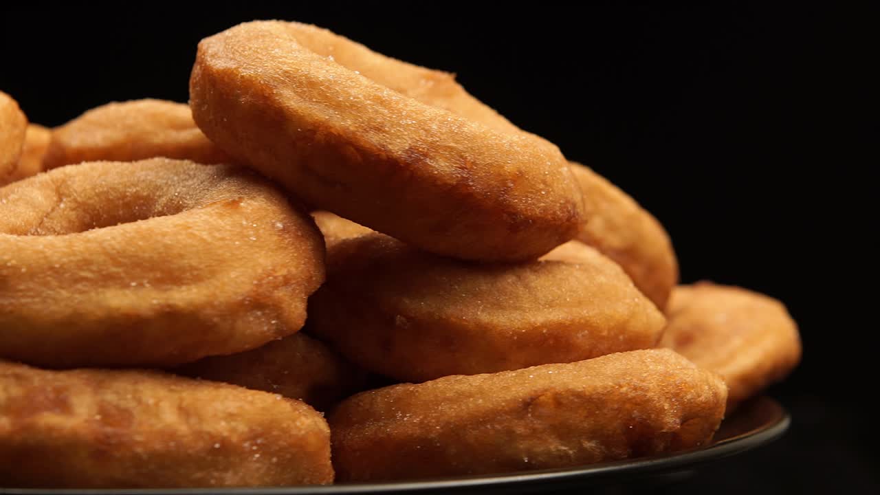 de lado de cerca: la pila de una rotación de rosquillas en un fondo negro