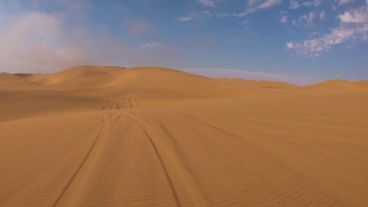 Ripresa POV dalla parte anteriore di un veicolo safari che si muove attraverso sabbia profonda e dune nel deserto del Namib in Namibia 3