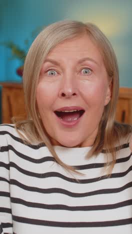 excited mature woman surprised shocked by sudden victory good win news celebrating wow reaction
