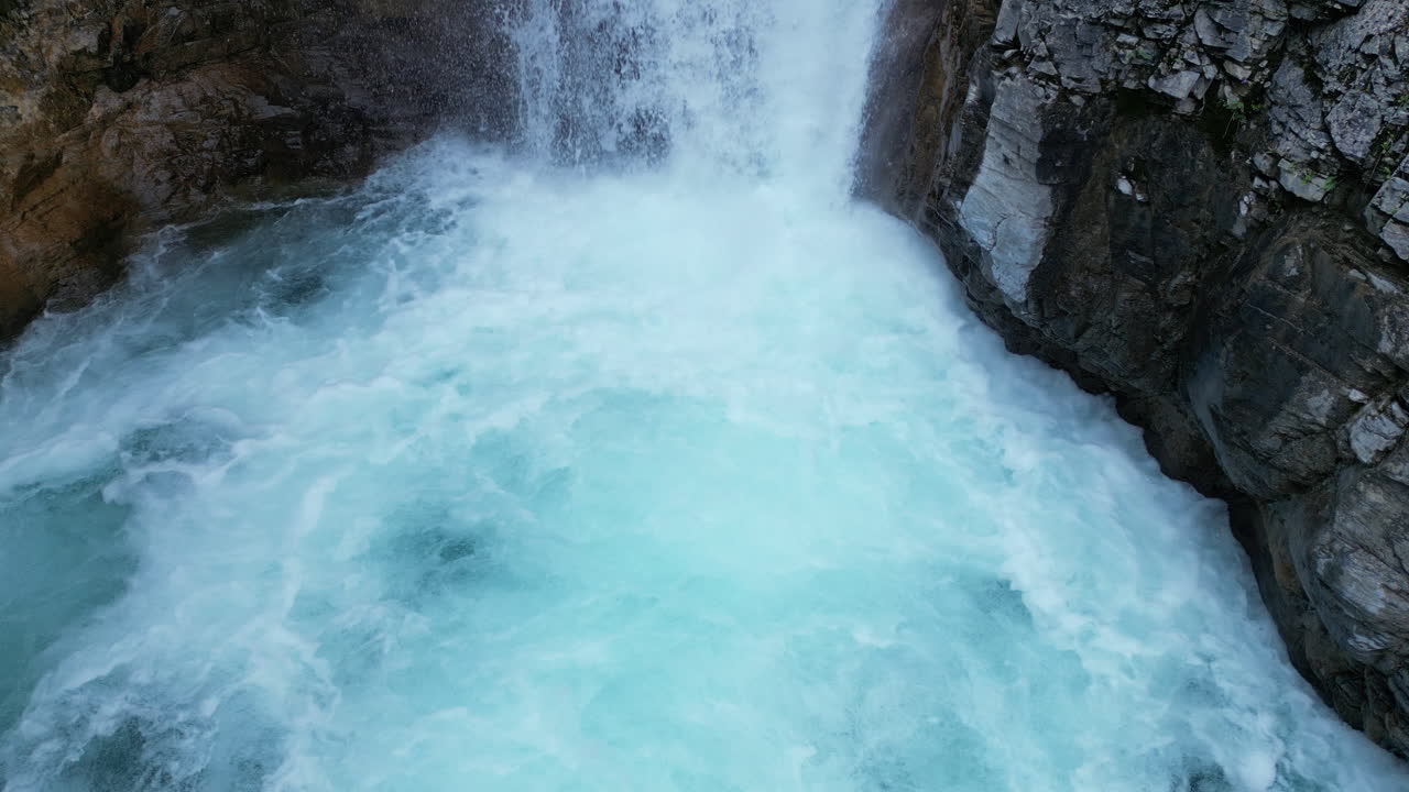 Cascata che si riversa in una pozza gorgogliante di acqua blu [4K Slow Motion