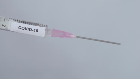 hand of a physician removes the needle cap of syringe with covid-19 vaccine