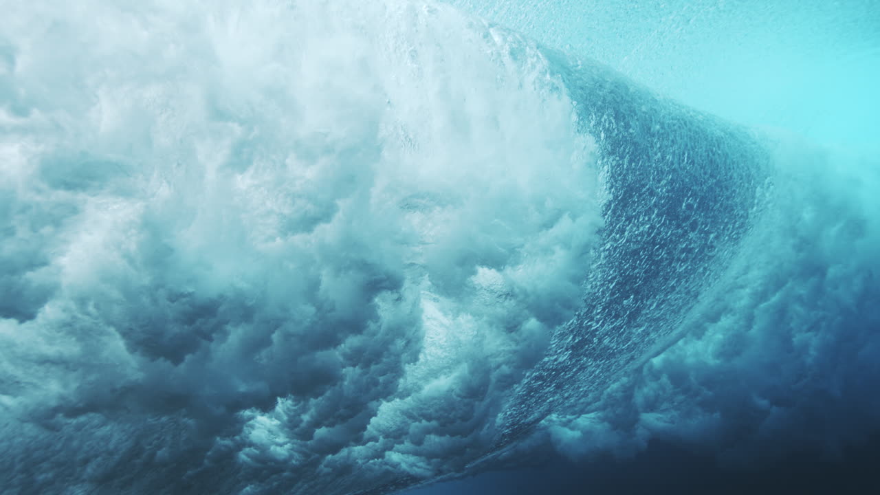 Curving underwater wave wall glowing turquoise with smooth flowing ocean texture