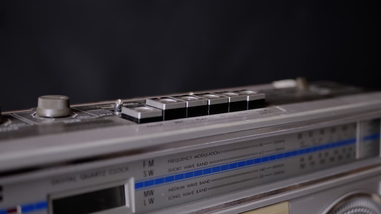 어두운 방에서 오래된 빈티지 테이프 레코더의 버튼을 누르는 여성 손가락