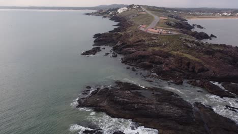 aerial view of rocky coastline with viewpoint in punta ballena area en punta del este,uruguay - orbit shot