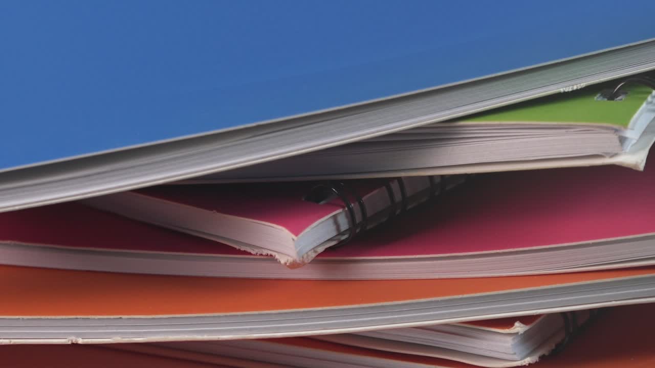 Close Shot of Different Colored Notebooks Rotating
