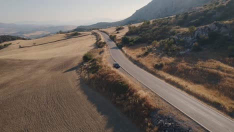 Luftdrohne-Rückwärts-Bewegter-Schuss-über-Kurvenreiche-Straße-Entlang-Hügeligem-Gelände-In-El-Torcal-Park-Ridge-Spanien,-Antequera,-Malaga-In-Der-Abenddämmerung