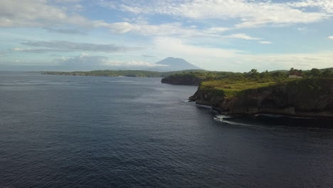 aerial tour boat rounds point below tall rocky