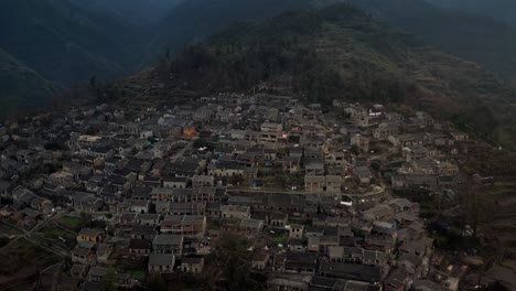 Antiguo-Pueblo-Chino-En-El-Lado-Oscuro-De-La-Montaña-Por-La-Noche