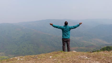 hombre caminando solo en la cima de una colina con un fondo de furia montañosa brumosa desde un video de ángulo plano tomado en nongjrong meghalaya india