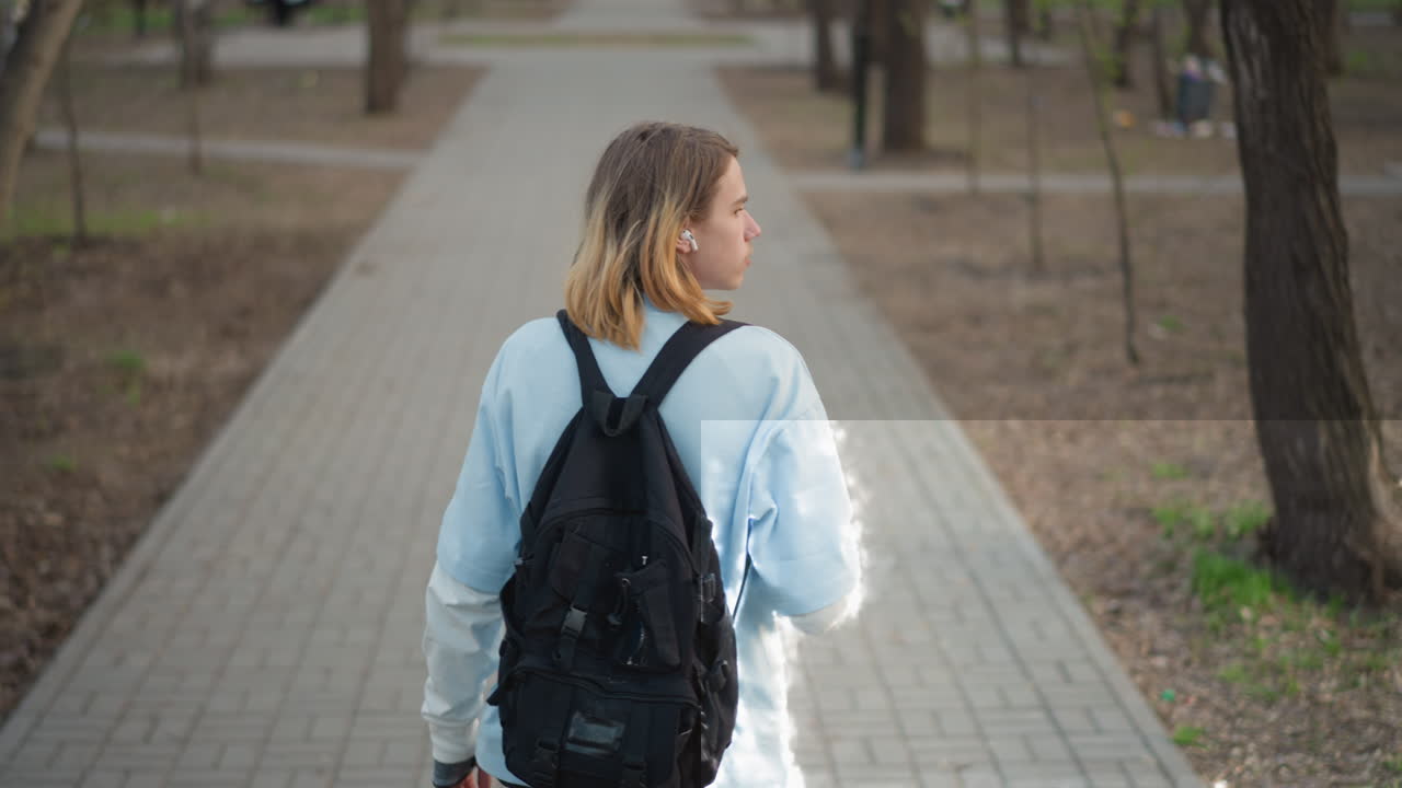 여행자가 뜨거운 커피 맛을 음미하기 위해 길을 걷다 잠시 멈춰 섰습니다. 배낭을 멘 사색에 잠긴 등산객이 걷다가 잠시 멈춰 음료를 마십니다. 눈에 띄는 끈을 맨 편안한 탐험가가 경치 좋은 길의 잎 없는 나무들 사이에서 한 모금 마시는 것을 즐깁니다.
