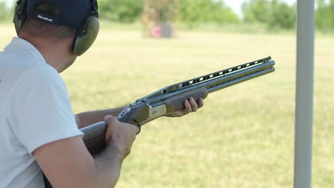 sportsman shoots from a double-barreled shotgun, a sports field for a shooting test is shooting at flying skeet