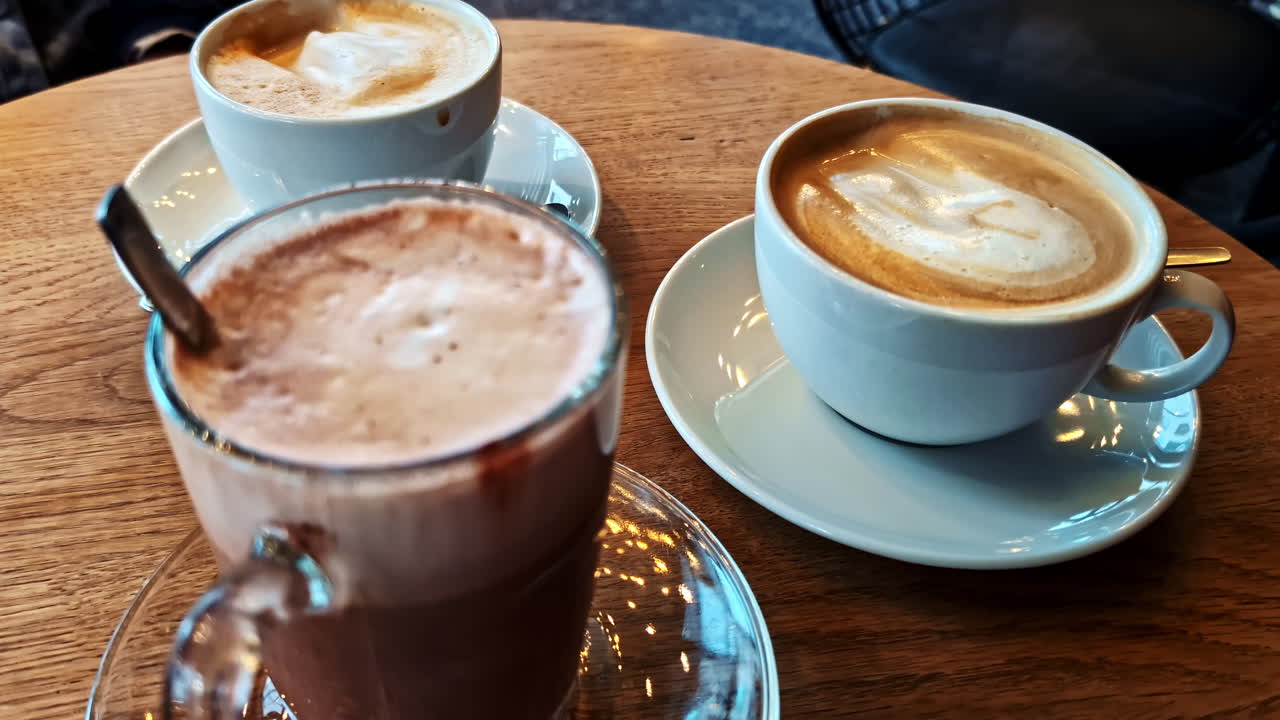 Coffee and hot chocolate drinks served on wooden table in cozy café