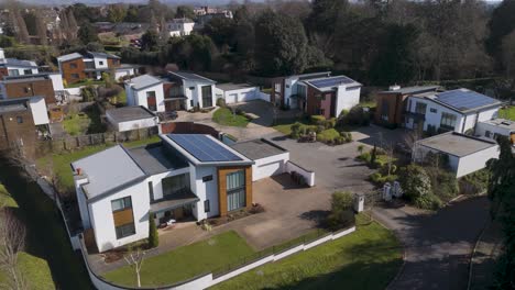 aerial of looping tree-lined roads flanked by evenly spaced solar homes with private lawns and driveways demonstrating ordered green masterplan