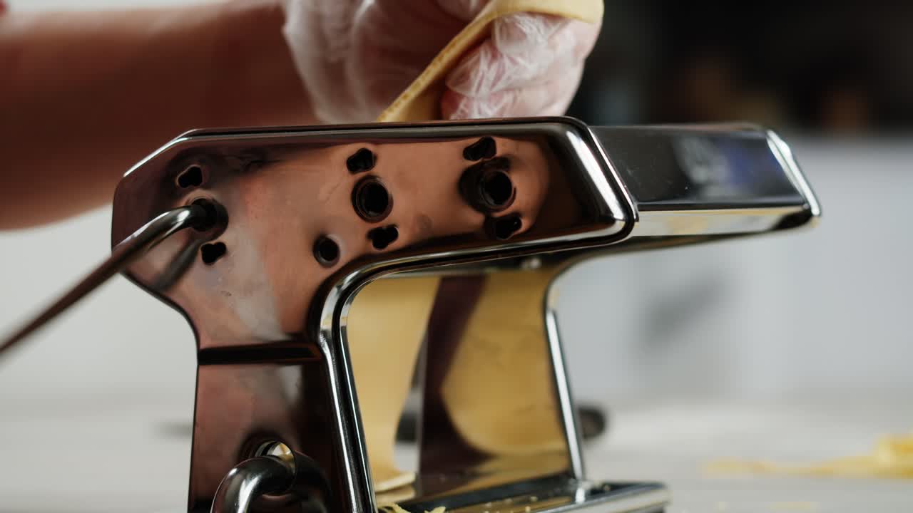 Close-up of Hand Feeding Dough into a Pasta Maker Machine