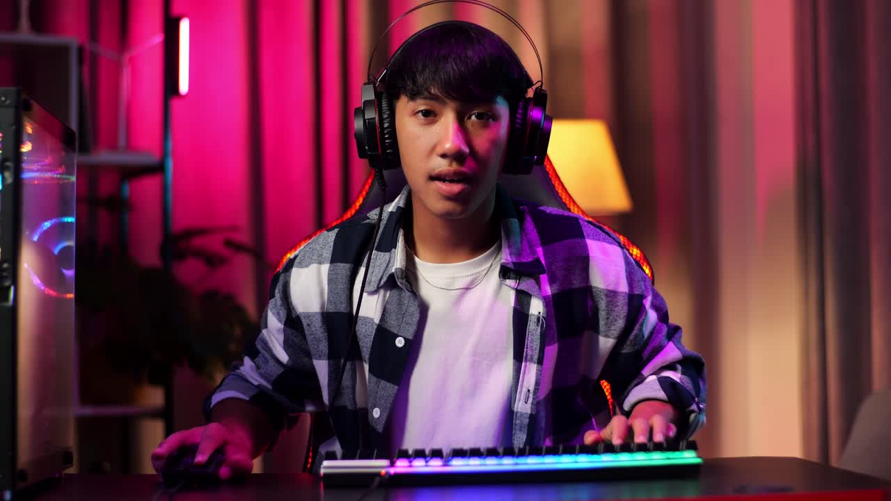 Front View Of Excited Asian Teen Boy Gamer Celebrates Victory And Dancing While Playing Video Game On Computer