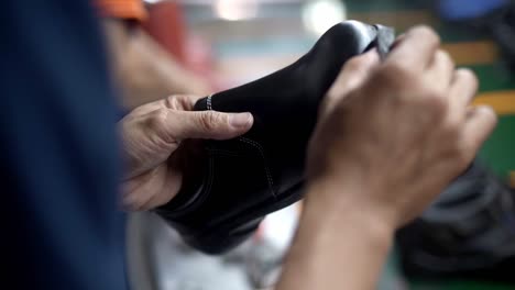 hand meticulously applies shoe shiner to a shoe making it shine