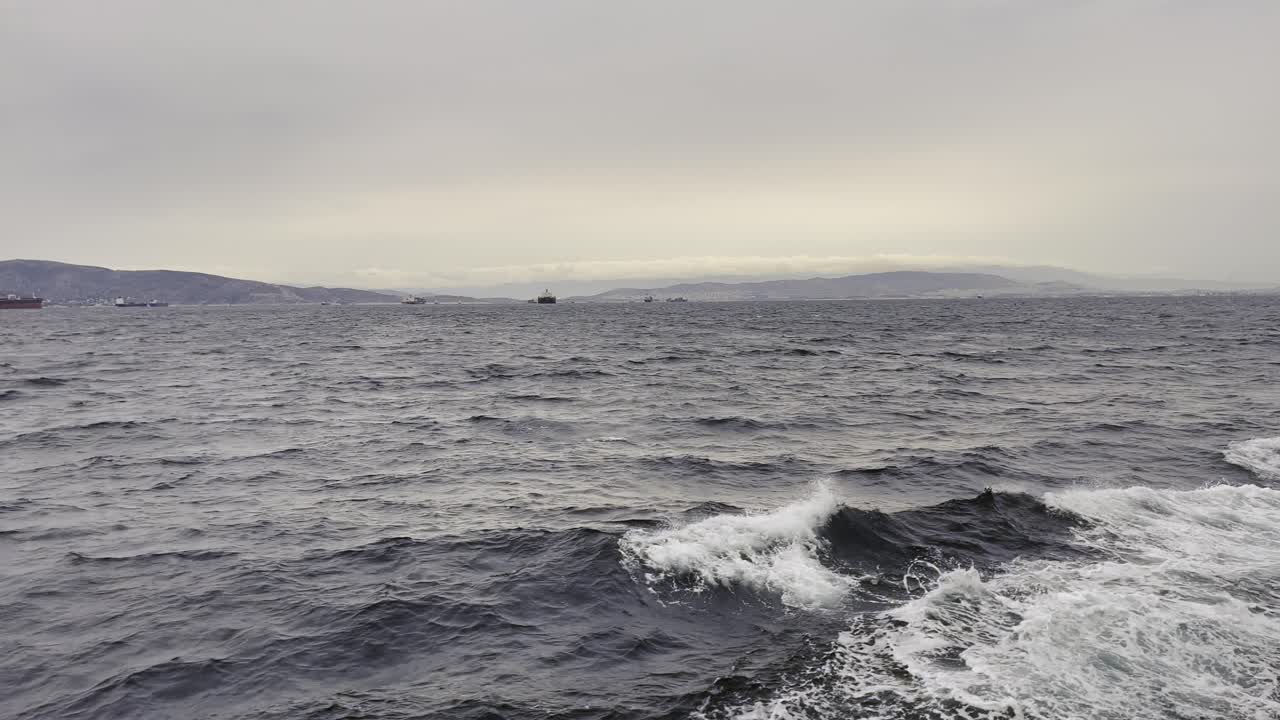 흐린 날 에 움직이는 선박 에서 나오는 바다 파도 들 이 느리게 움직인다