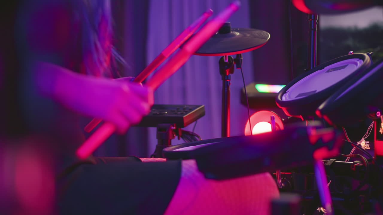 Lady dressed in fishnet pantyhose plays electronic drum set in studio filled with moody ambient lights, vibrant purple tones reflect creative energy as her hands grip drumsticks mid-performance