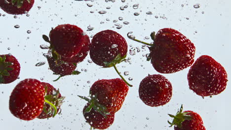 Agua-Flotante-De-Fresa-Fresca-En-Cámara-Súper-Lenta-De-Cerca.-Baya-En-Líquido.