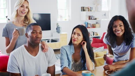 Group-Of-Young-Friends-Chatting-And-Drinking-Coffee-In-Kitchen