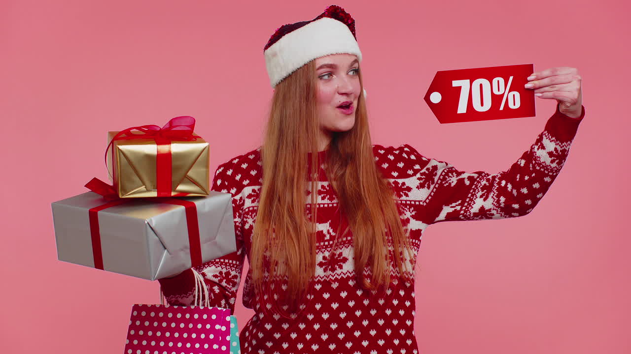 mujer con suéter de navidad mostrando caja de regalos y inscripciones de descuento del 70 por ciento nota de texto de banner