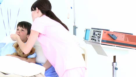 病院で小さな男の子の喉をチェックする看護師