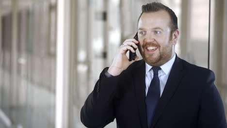 a businessman receives good news as he uses his cell phone