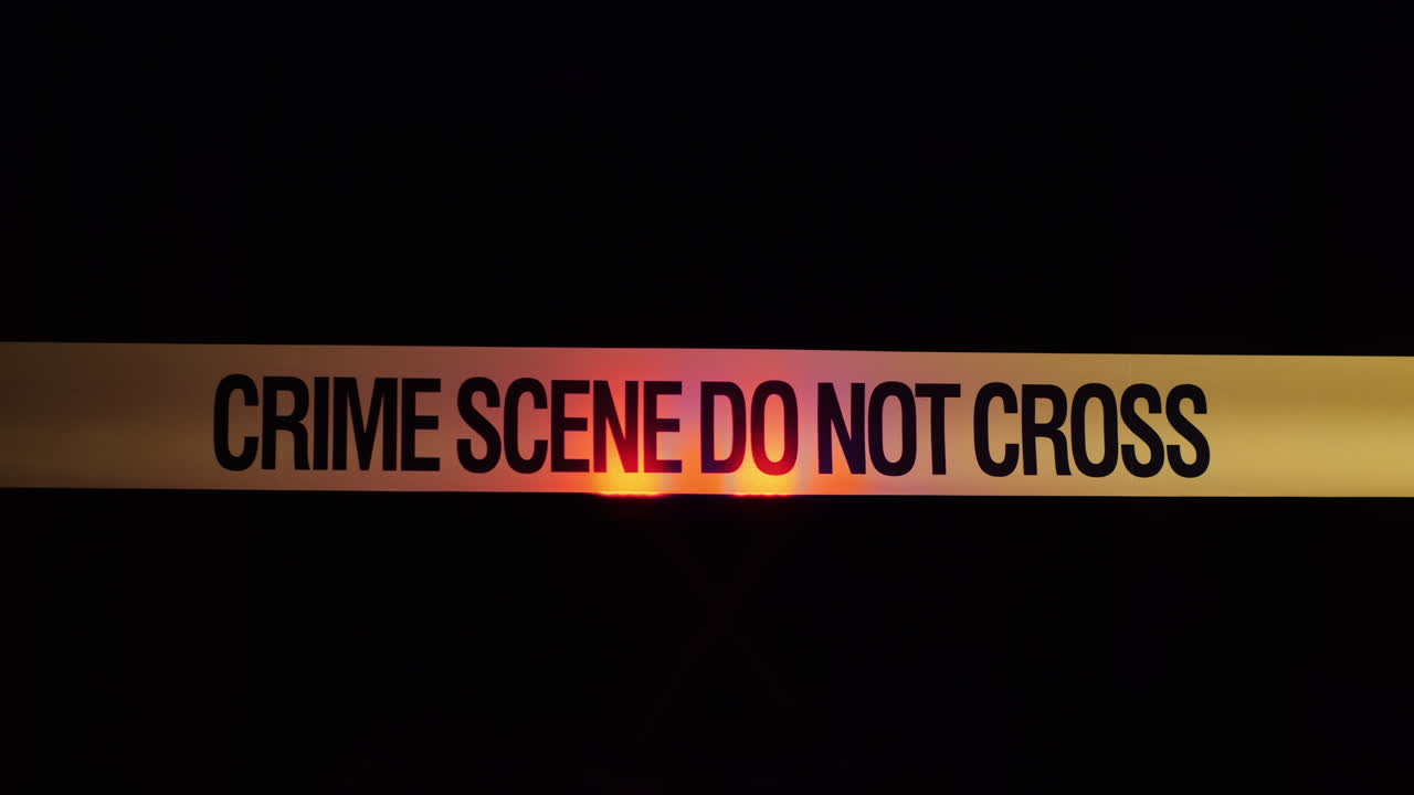 Barrier tape at crime scene with police flashing lights 1