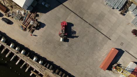 Top-down-drone-shot-of-red-forklift-putting-cargo-on-the-wagons