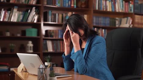 The-woman-is-sitting-at-the-table-and-working-on-her-laptop