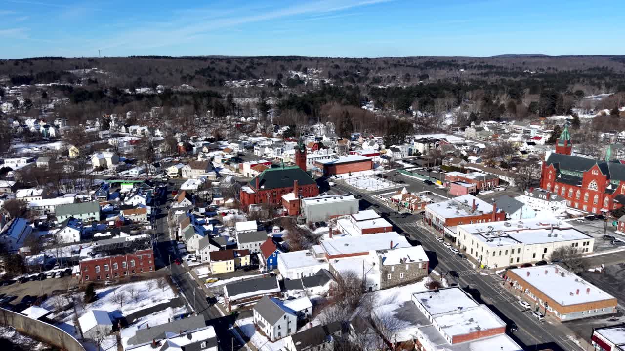Massachusetts, Ware şehir merkezinin havadan kış görünümü; karla kaplı çatılar, tarihi binalar, sokaklar ve ağaçlık tepelerle çevrili küçük kasaba merkezini açık gün ışığında gösteren geniş açı çekim.