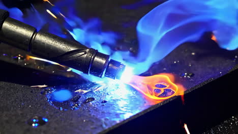 close-up of welding process with blue flame and sparks